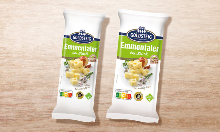 Emmentaler Stück - GOLDSTEIG Käsespezialitäten Emmentaler Stück von GOLDSTEIG in Verpackung auf Holztisch