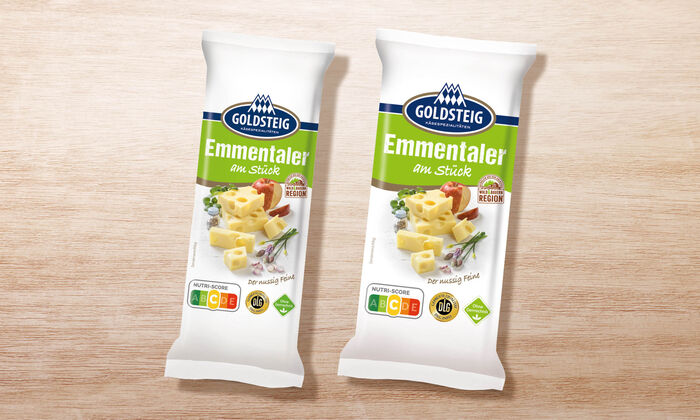 Emmentaler Stück - GOLDSTEIG Käsespezialitäten Emmentaler Stück von GOLDSTEIG in Verpackung auf Holztisch