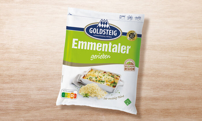 Emmentaler gerieben - GOLDSTEIG Käsespezialitäten Emmentaler gerieben von GOLDSTEIG in Verpackung auf Holztisch